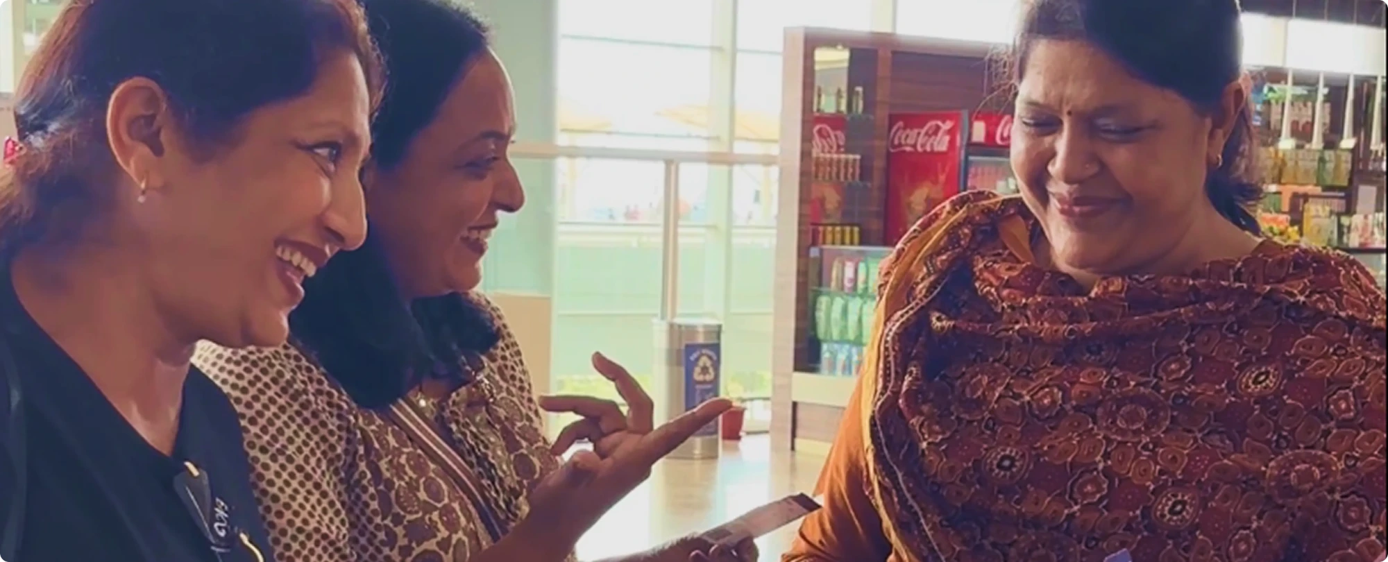 Three Sahelis laughing together at an airport café